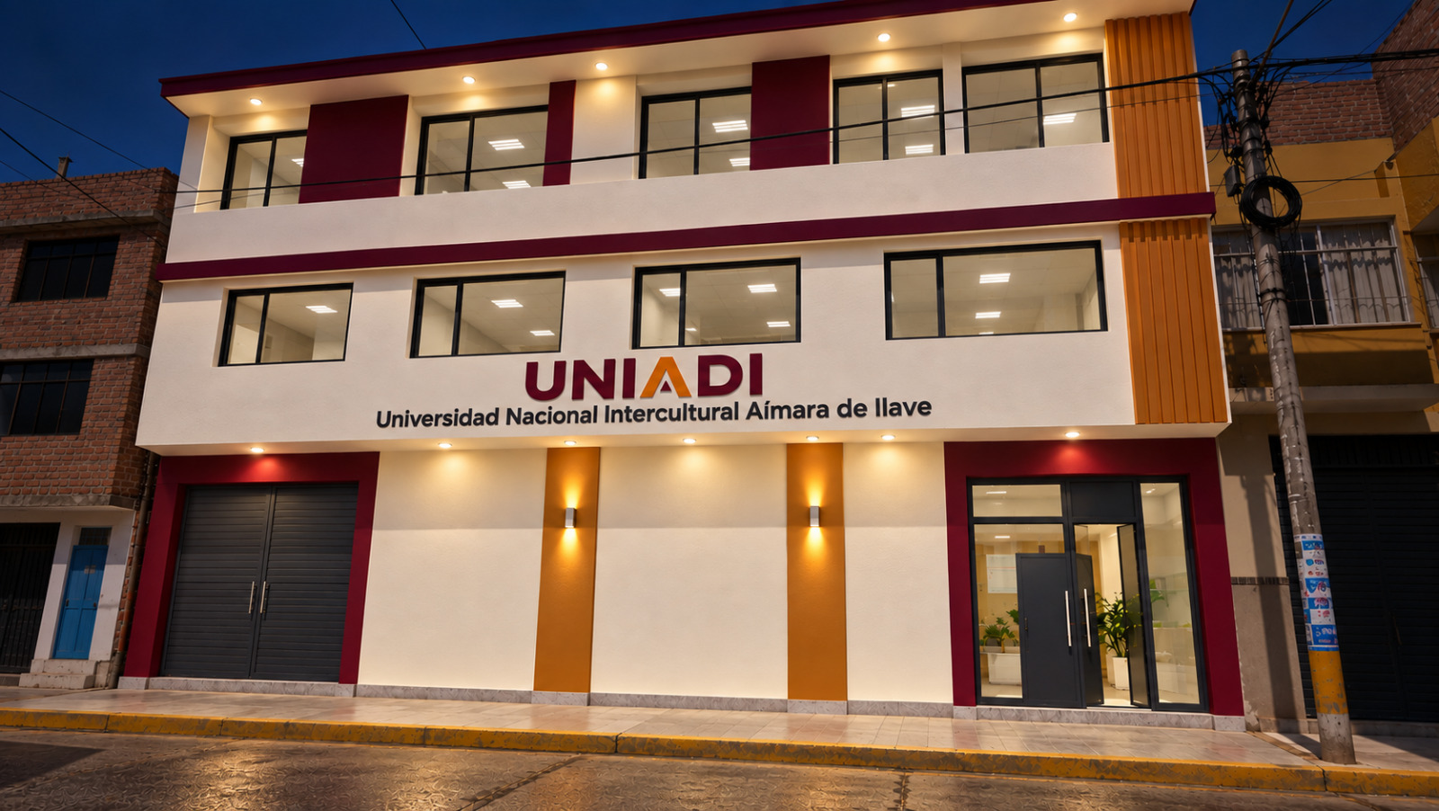 Fachada del local de UNIADI al atardecer, con el letrero institucional y la iluminación encendida.